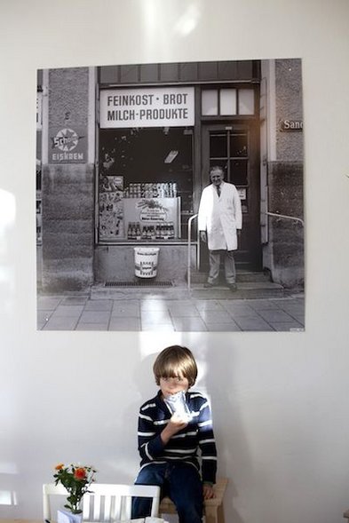 Junge vor dem Foto des ehemaligen Ladenbesitzers